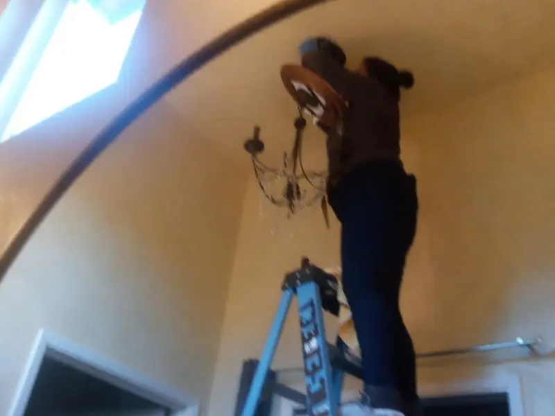 Electrician installing a chandelier in a Hoffman Estates residence